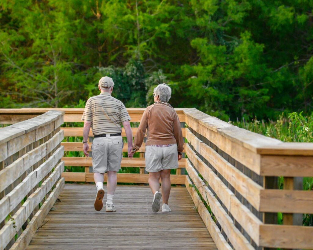 Gepensioneerd stel op houten brug tijdens wandeling in Spanje