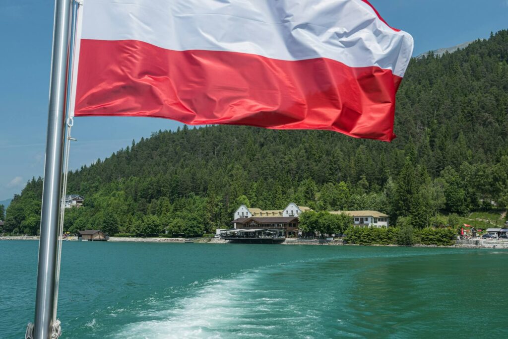 De Oostenrijkse vlag wapper op een boot op een meer.