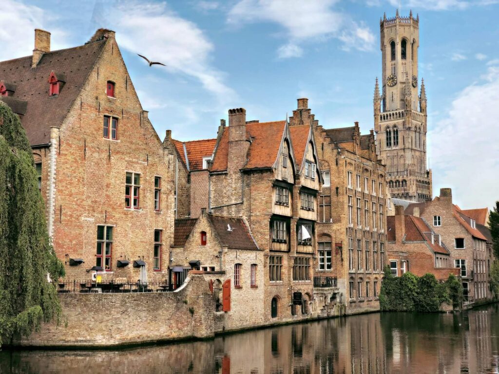 Historisch plein met klassieke Belgische gebouwen en torens bij helder weer.