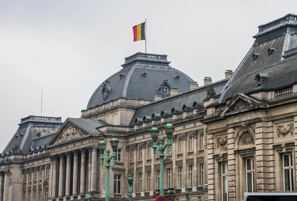 Historisch regeringsgebouw in België met koepel en Belgische vlag.