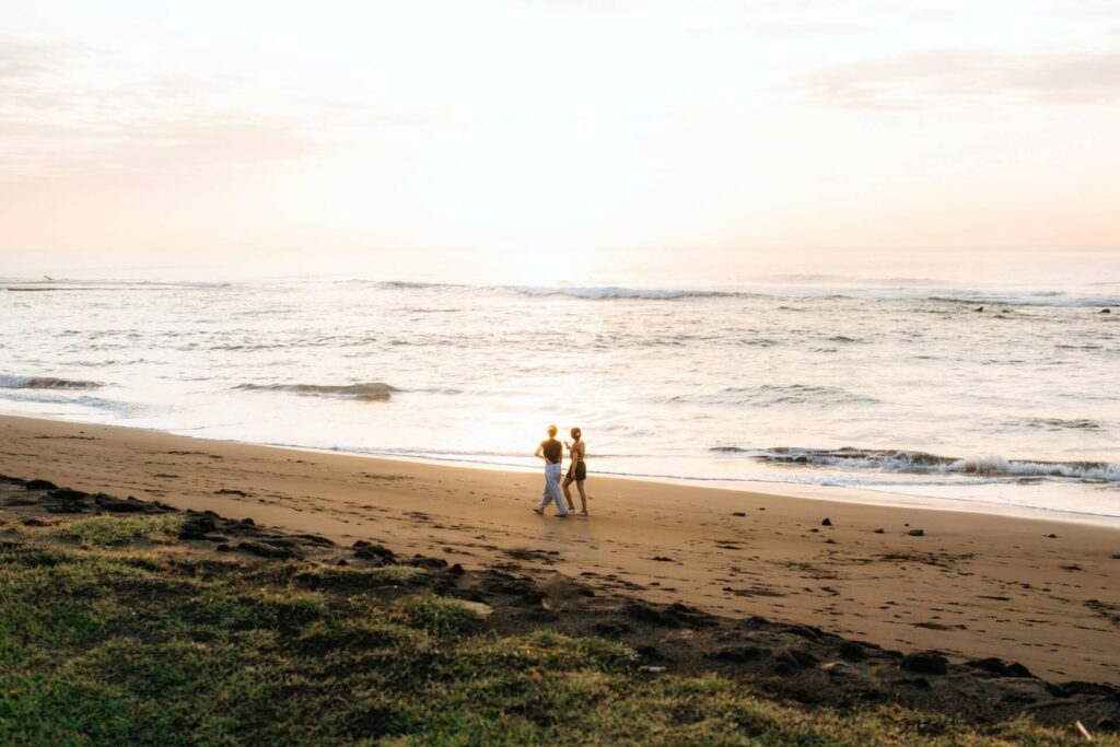 Twee mensen die lopen op een strand